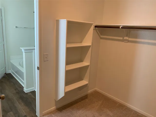 a view of walk in closet with empty racks