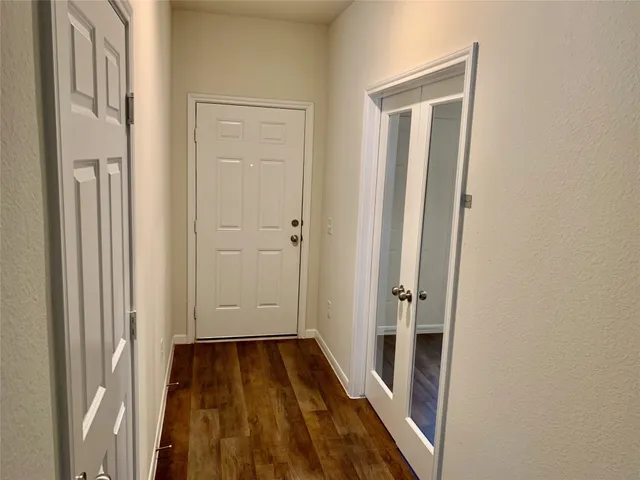a view of a hallway with wooden floor and closet