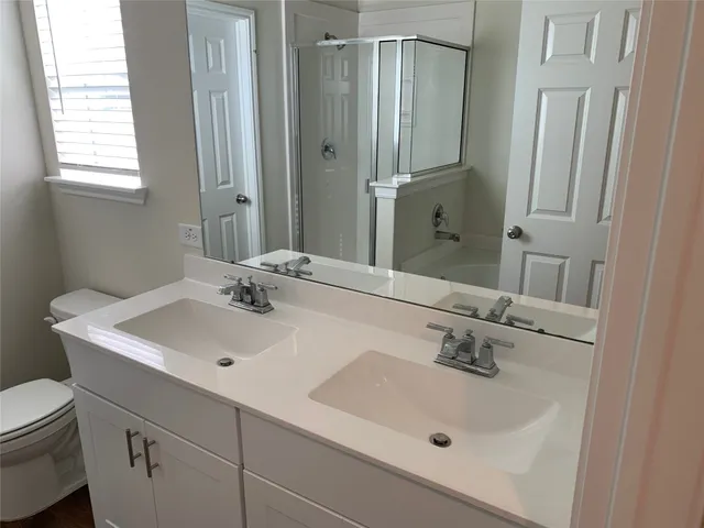 a bathroom with a sink a toilet and a mirror