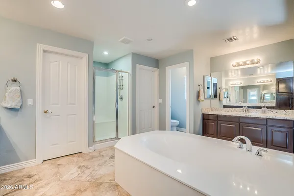 a spacious bathroom with a tub sink and mirror