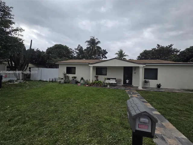 a front view of house with a garden and patio