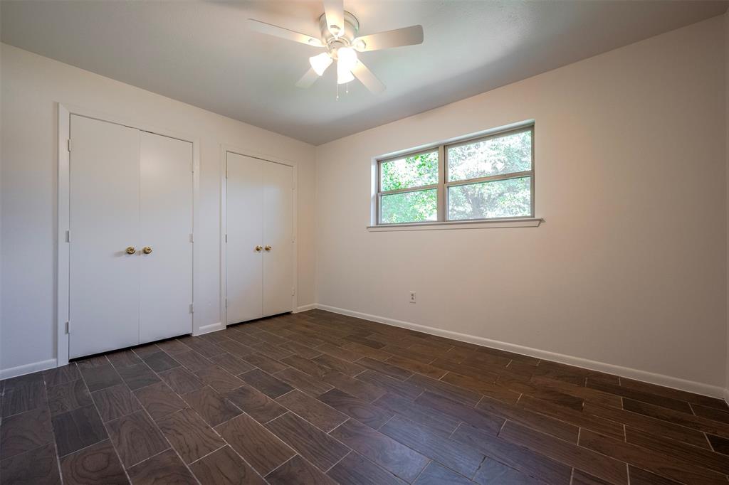 610 East Anderson Street Weatherford, TX 76086 - Photo 18 of 25 an empty room with wooden floor chandelier fan and windows