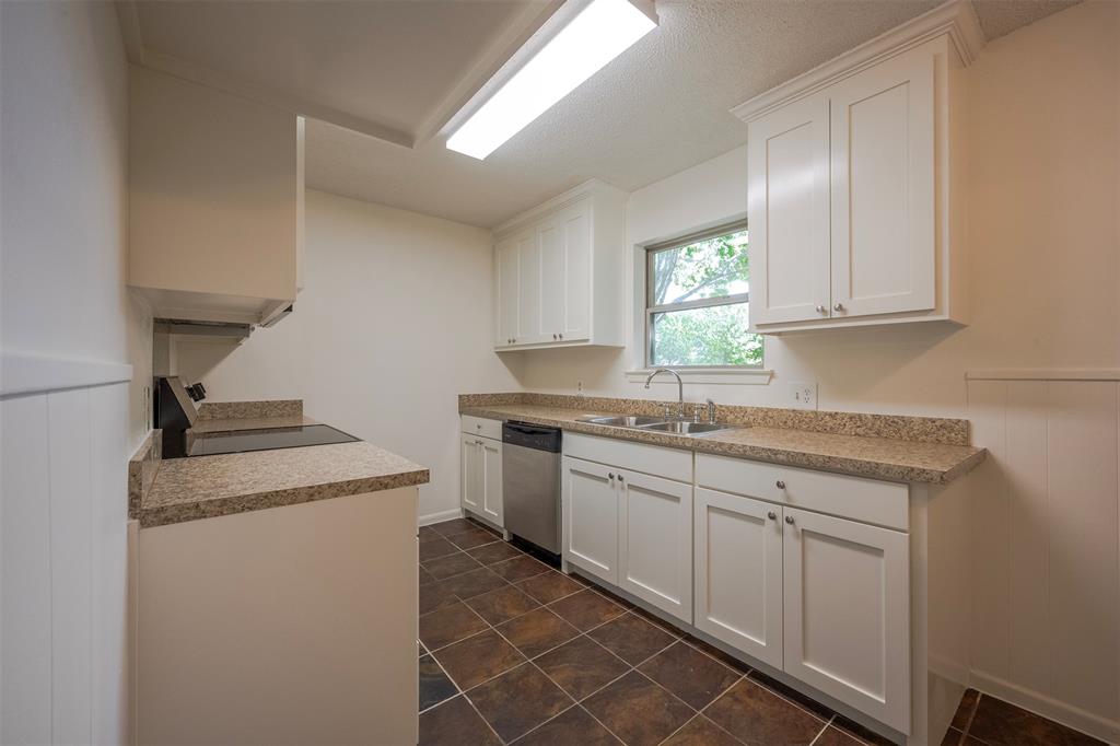 610 East Anderson Street Weatherford, TX 76086 - Photo 7 of 25 a kitchen with granite countertop cabinets stainless steel appliances a sink and a window