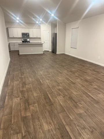a view of kitchen with kitchen island a sink wooden floor and black appliances