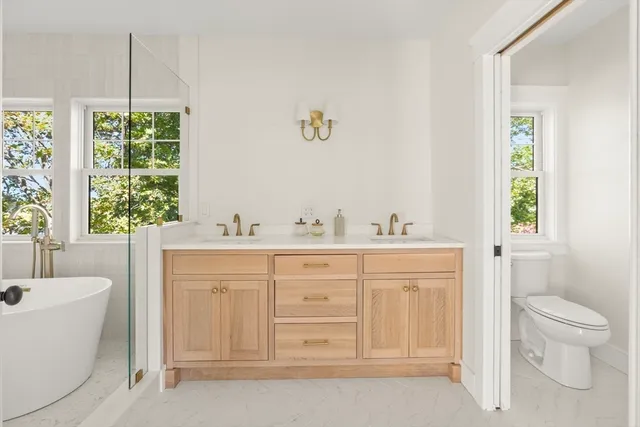 a bathroom with a double vanity sink a mirror and a bathtub