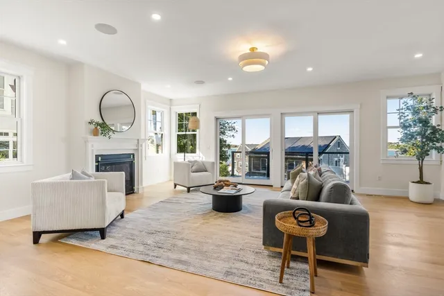 a living room with fireplace furniture and a large window