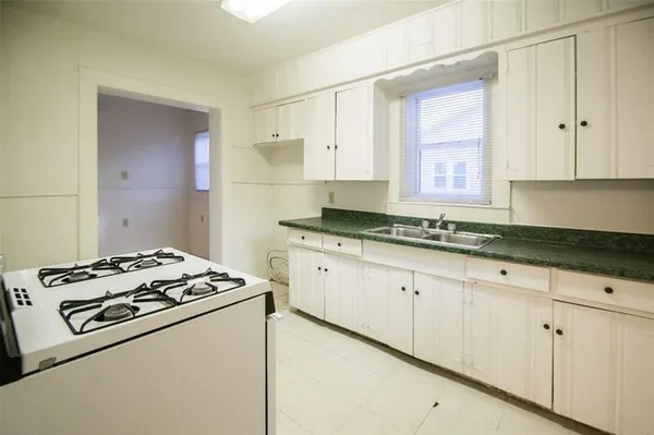 a kitchen with granite countertop white cabinets and white appliances