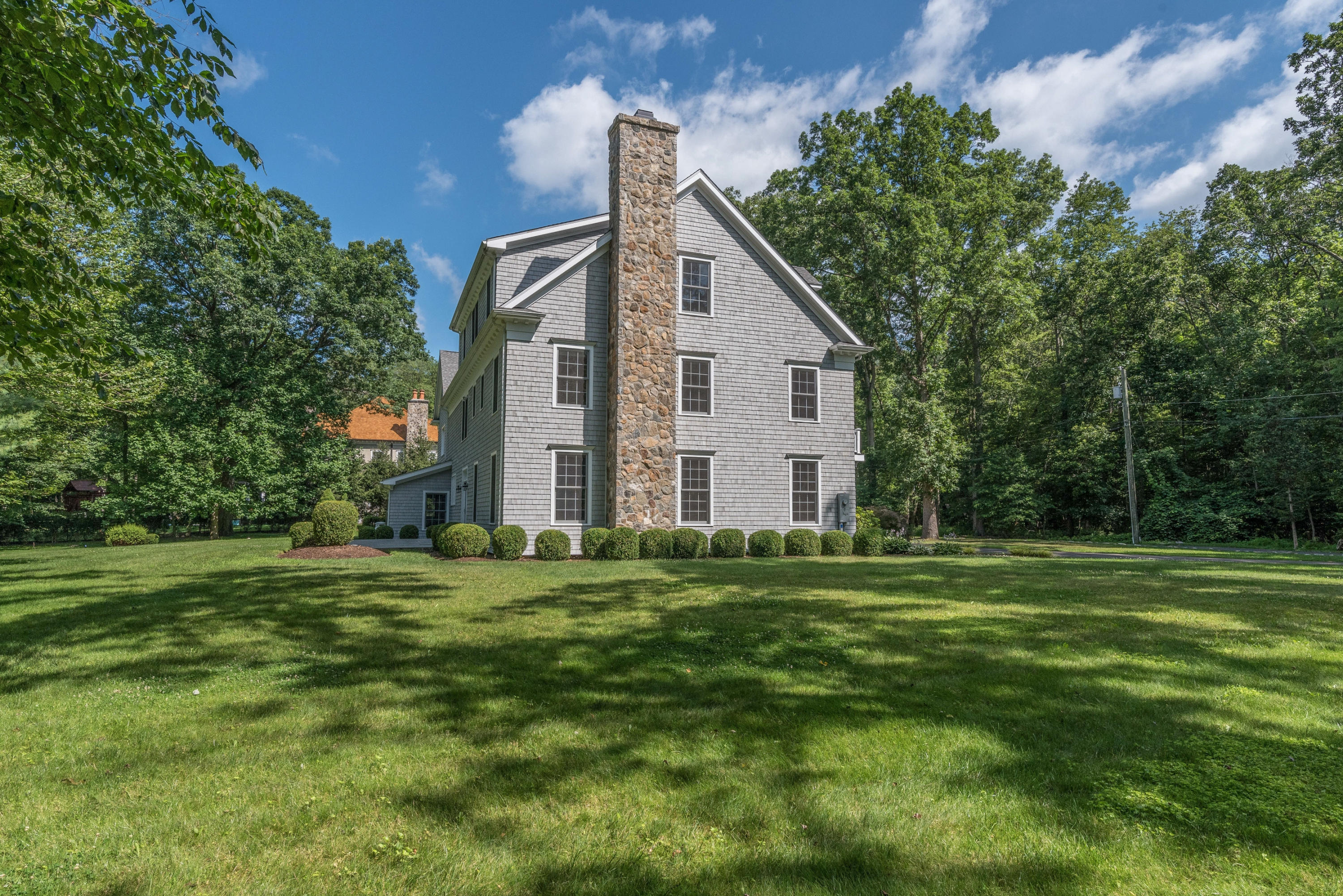 42 Mariomi Road New Canaan, CT 06840 - Photo 24 of 28 a front view of a house with a yard