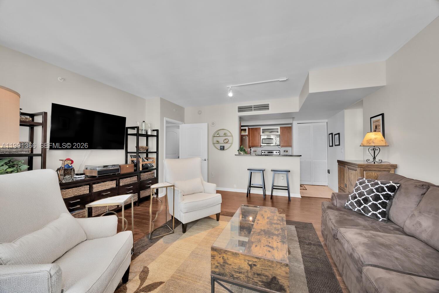 7350 Southwest 89th Street, Unit 1511S Miami, FL 33156 - Photo 3 of 29 a living room with furniture and a flat screen tv