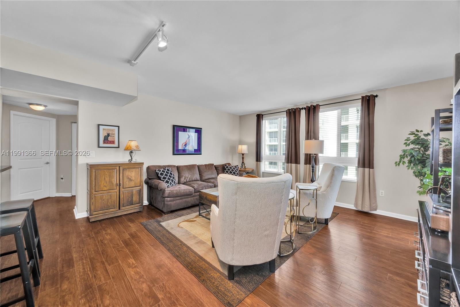 7350 Southwest 89th Street, Unit 1511S Miami, FL 33156 - Photo 4 of 29 a living room with furniture a large window and wooden floor