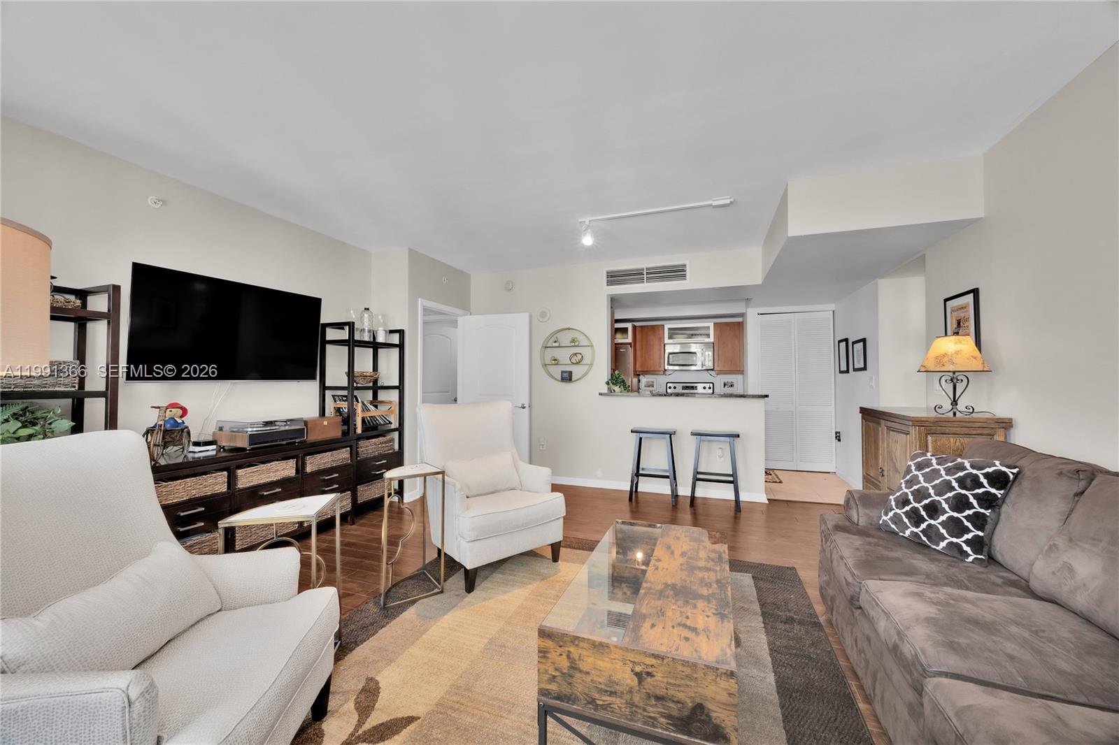 7350 Southwest 89th Street, Unit 1511S Miami, FL 33156 - Photo 5 of 29 a living room with furniture and a flat screen tv