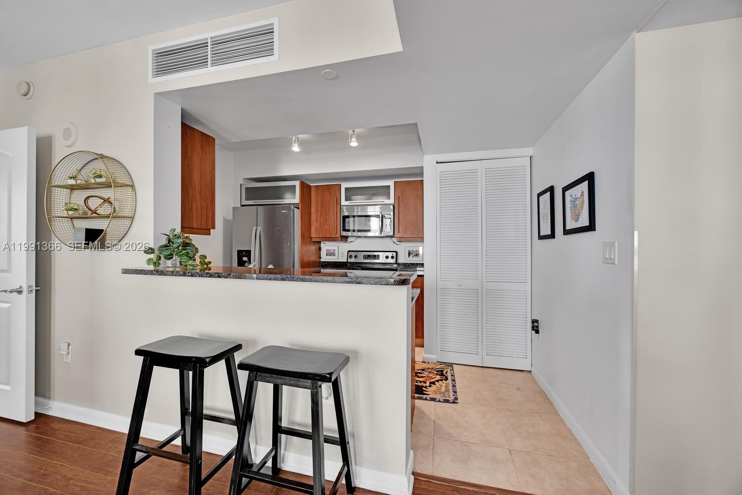 7350 Southwest 89th Street, Unit 1511S Miami, FL 33156 - Photo 6 of 29 a kitchen with stainless steel appliances granite countertop a refrigerator and a stove top oven
