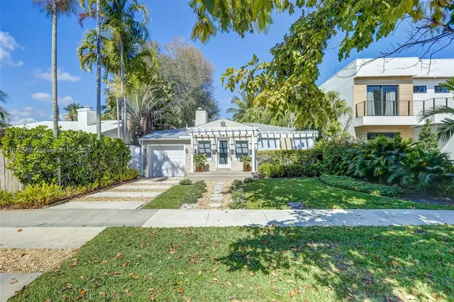 a view of a house with a yard and potted plants