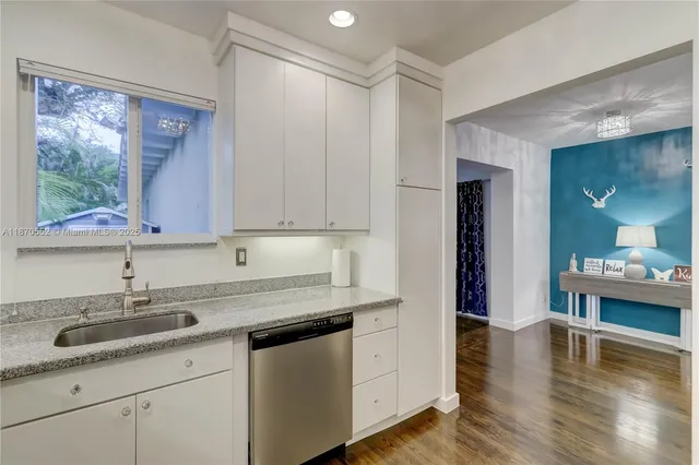 a kitchen with a sink cabinets and wooden floor