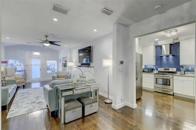 a living room with stainless steel appliances kitchen island granite countertop furniture and a view of kitchen