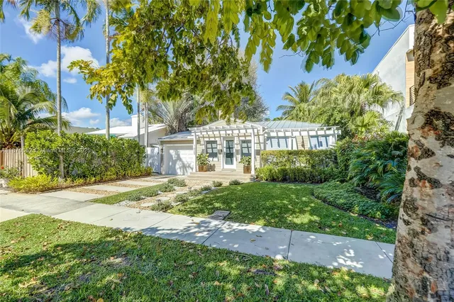 a view of a yard front of house with a yard and potted plants