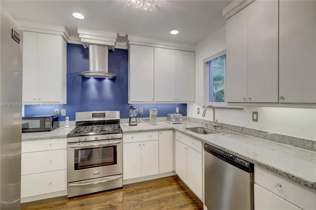 a kitchen with stainless steel appliances granite countertop a sink stove and cabinets