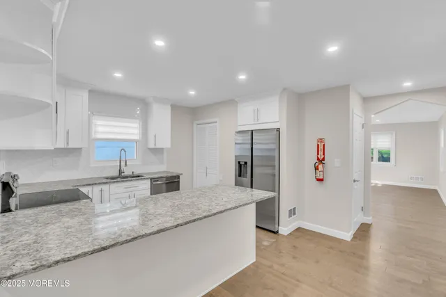 a kitchen with stainless steel appliances granite countertop a refrigerator and a sink