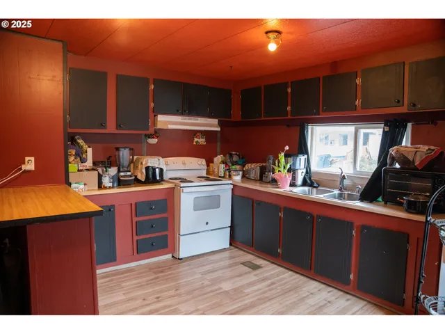 a kitchen with stainless steel appliances kitchen island granite countertop a table and chairs in it