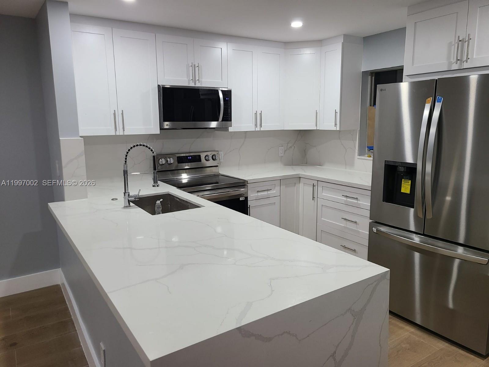 2980 Riverside Drive, Unit 1253 Coral Springs, FL 33065 - Photo 12 of 18 a kitchen with stainless steel appliances a refrigerator sink and microwave