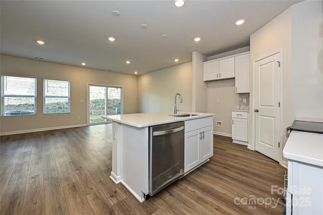a kitchen with a sink wooden floor and a large window