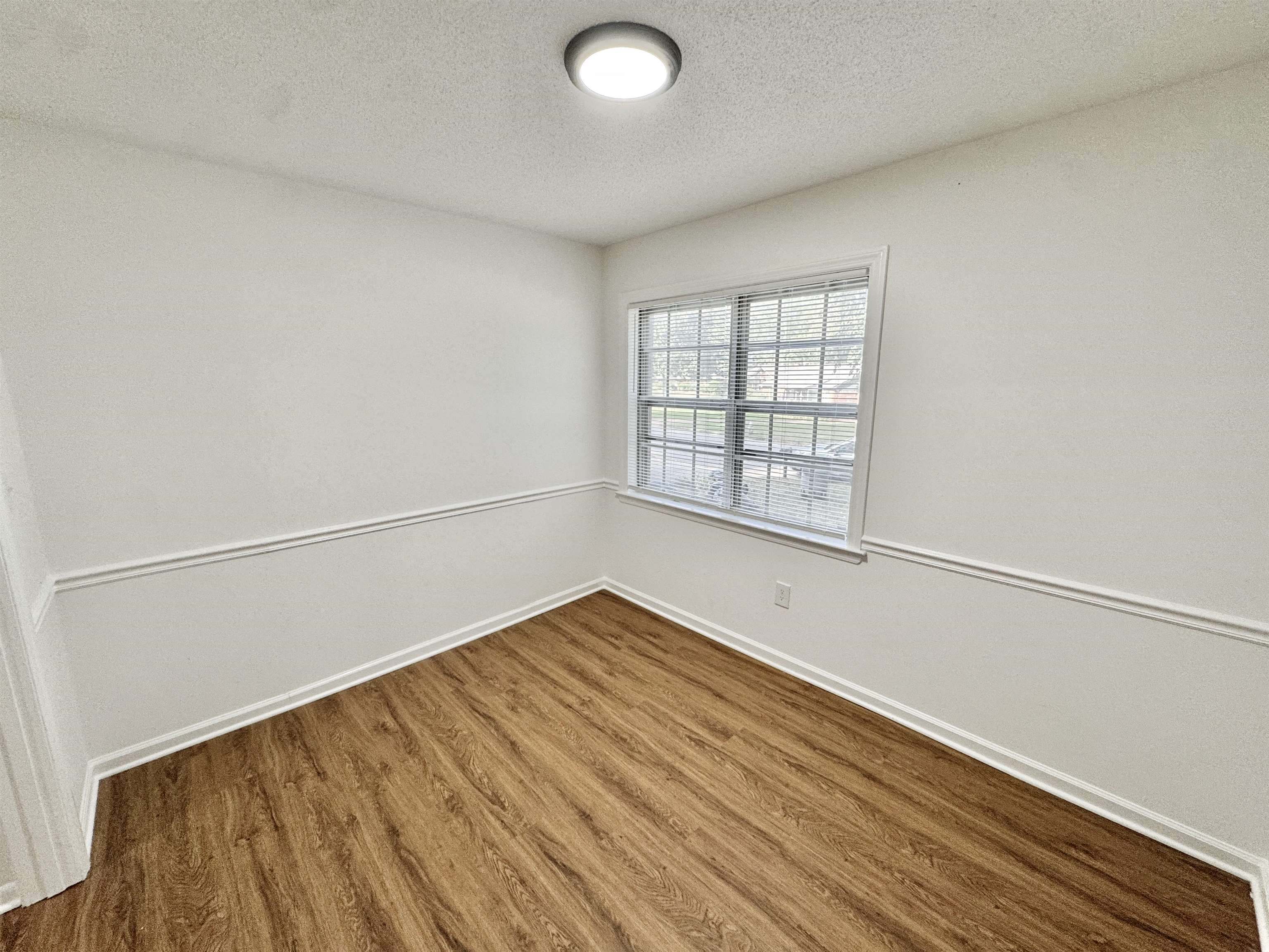 3209 Canyon Road Memphis, TN 38134 - Photo 10 of 30 an empty room with wooden floor and windows