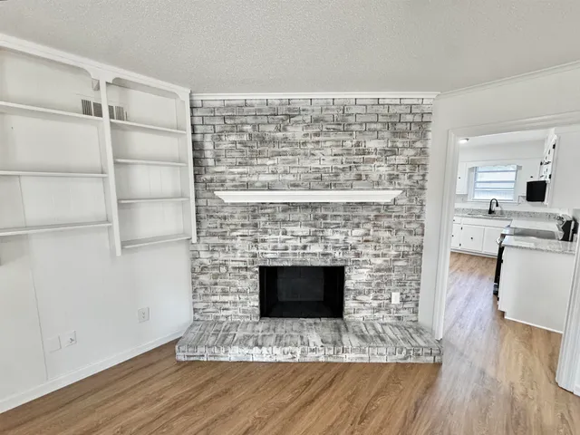 a living room with a fireplace and wooden floor