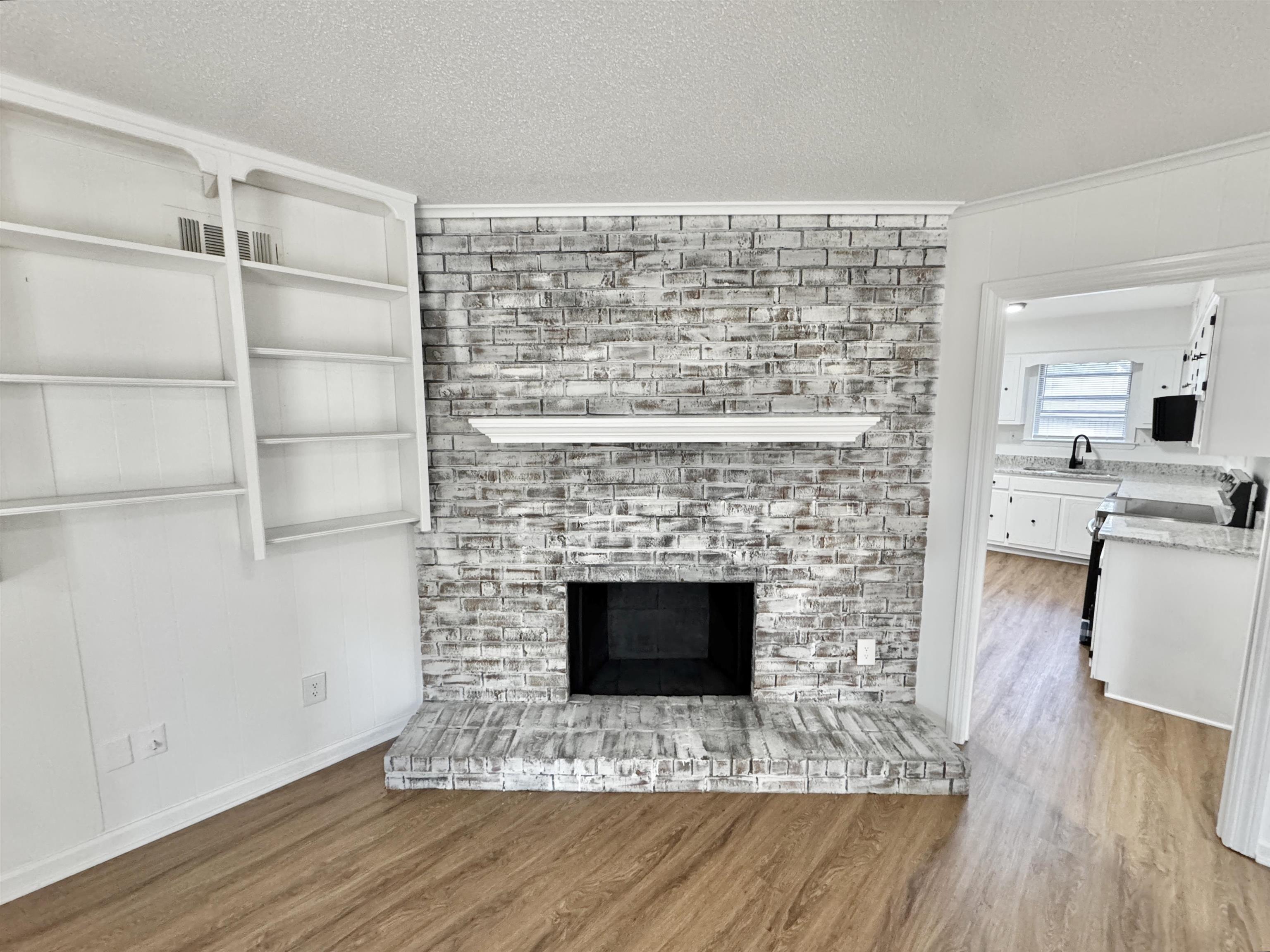 3209 Canyon Road Memphis, TN 38134 - Photo 4 of 30 a living room with a fireplace and wooden floor
