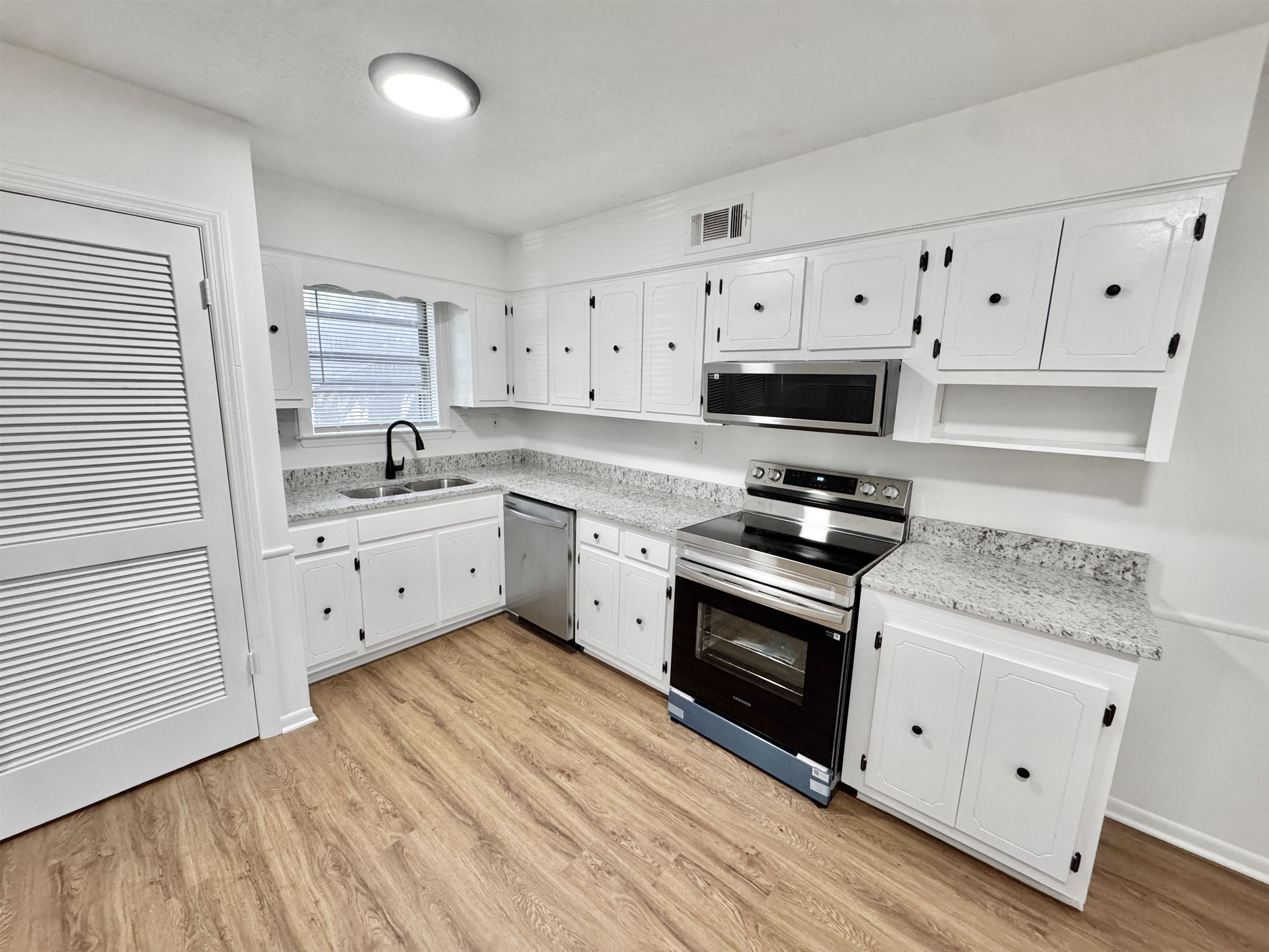 3209 Canyon Road Memphis, TN 38134 - Photo 6 of 30 a kitchen with cabinets stainless steel appliances and wooden floor