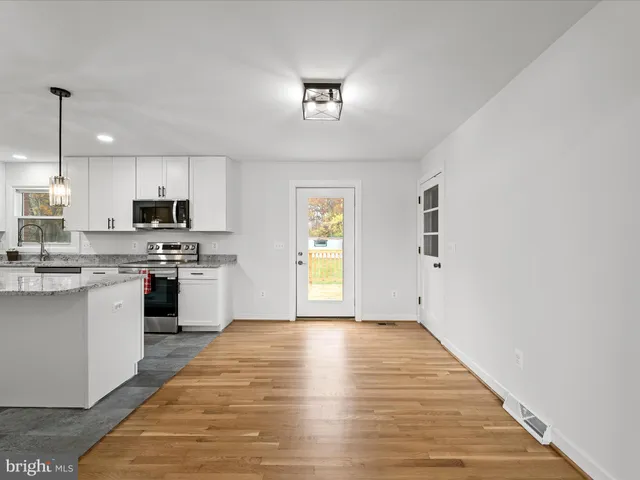 a view of a balcony with wooden floor and fence next to a yard