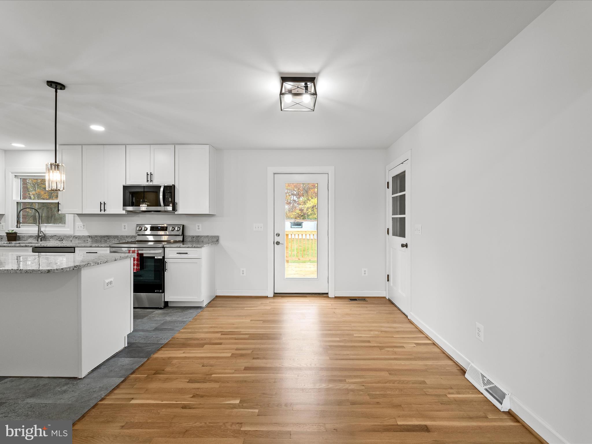 2311 Summit Point Road Summit Point, WV 25446 - Photo 11 of 46 a kitchen with granite countertop a refrigerator cabinets and wooden floor