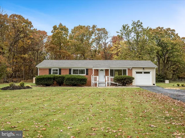 a view of a house with a yard and large tree
