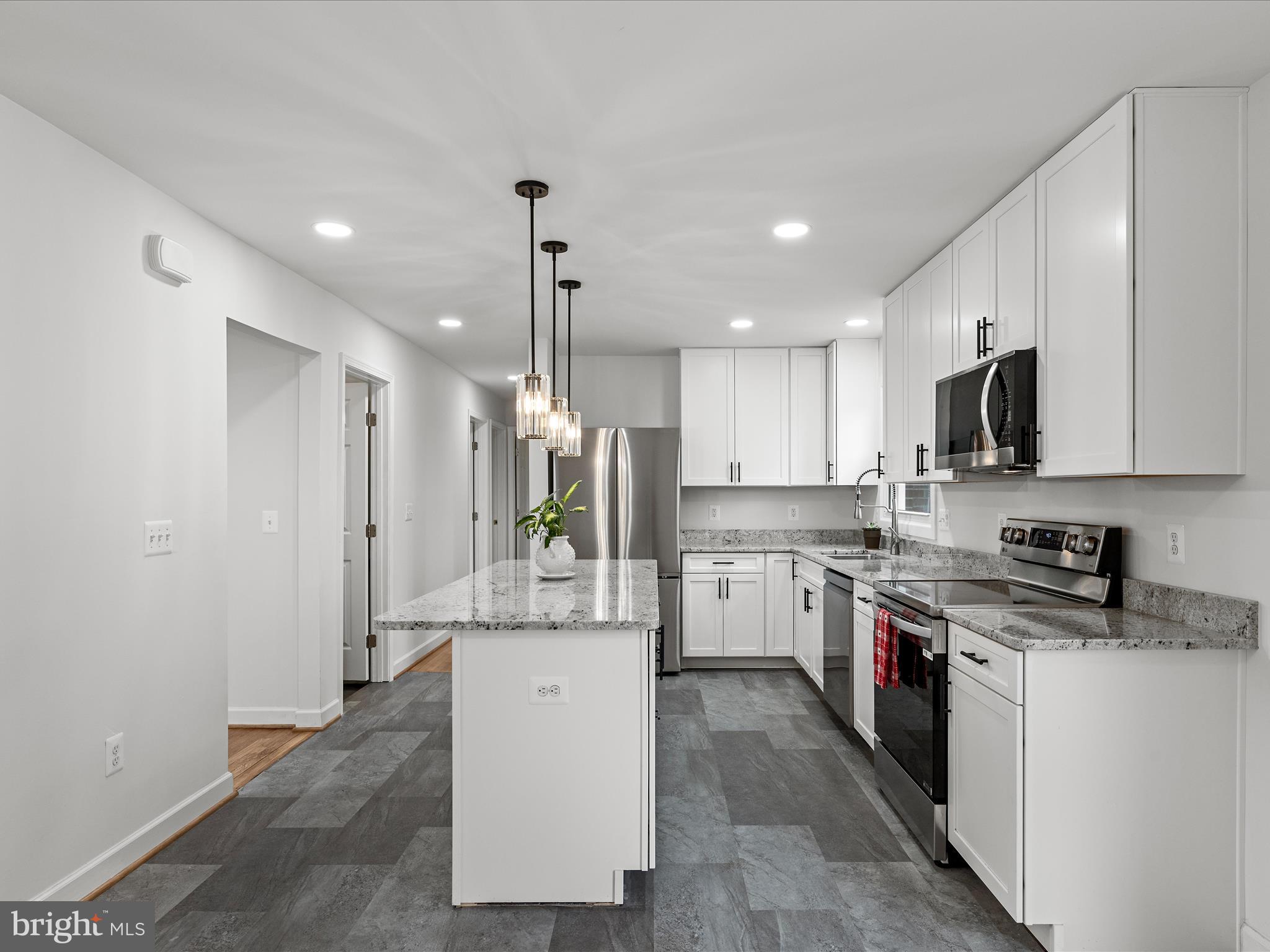 2311 Summit Point Road Summit Point, WV 25446 - Photo 8 of 46 a kitchen with a sink a counter top space stainless steel appliances and cabinets
