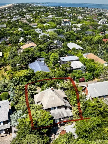 an aerial view of a house with a yard and green space