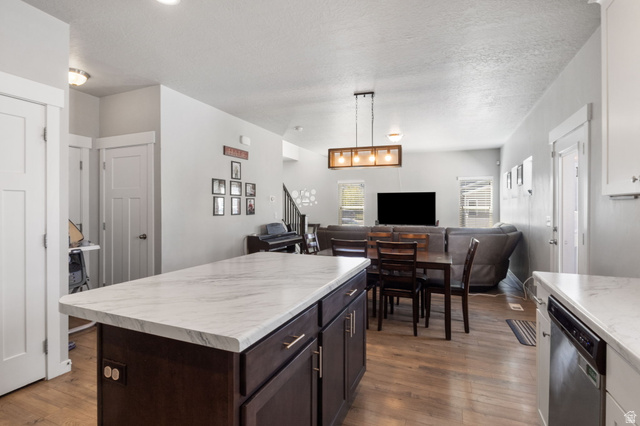 5155 East Rio Grande Way Eagle Mountain, UT 84005 - Photo 40 of 40 Kitchen with open floor plan, light countertops, dark wood finish cabinets, a kitchen island, and a textured ceiling