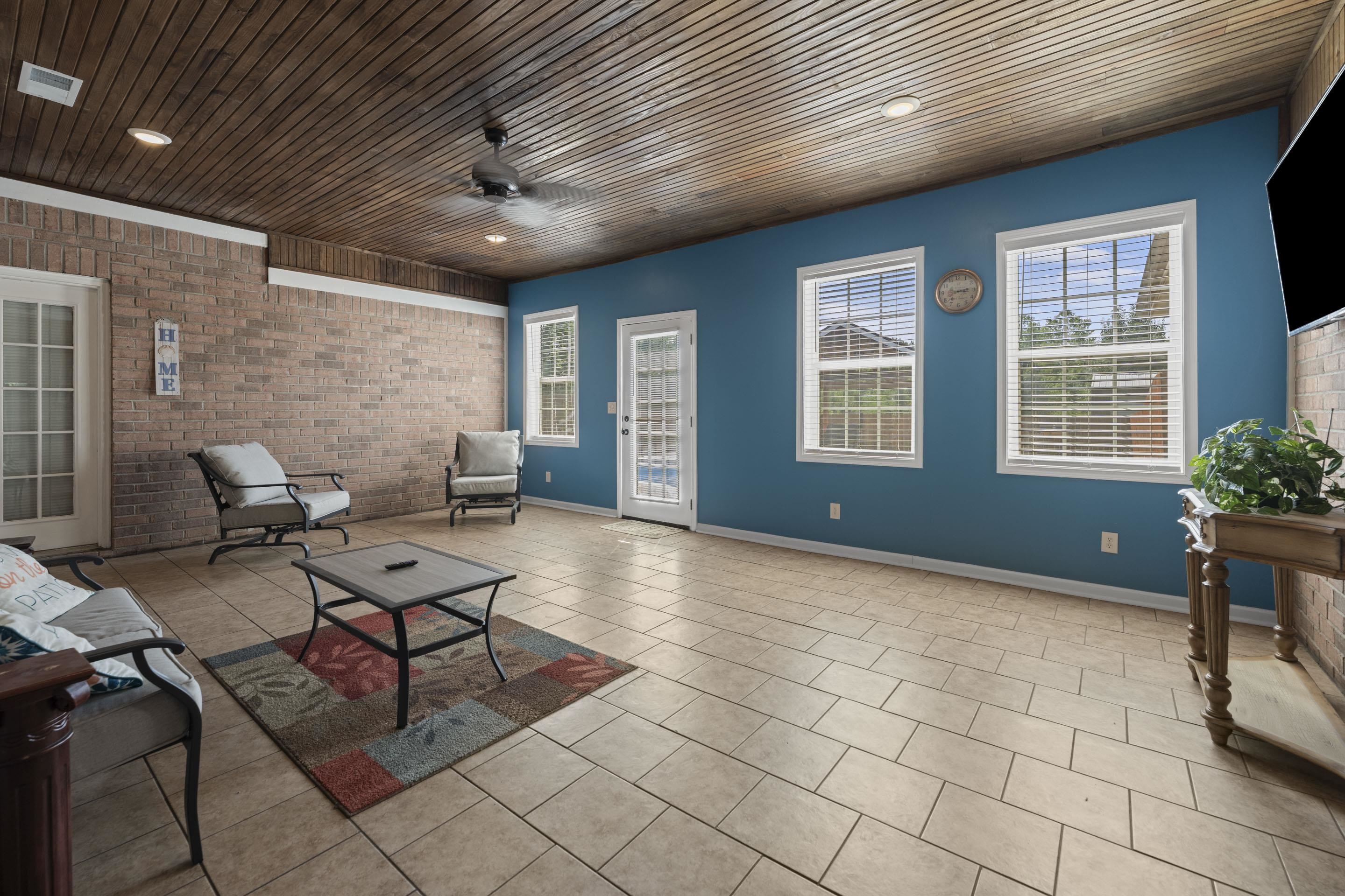 7265 Ward Road Millington, TN 38053 - Photo 20 of 29 Tiled living room with brick wall, healthy amount of natural light, ceiling fan, and wood ceiling