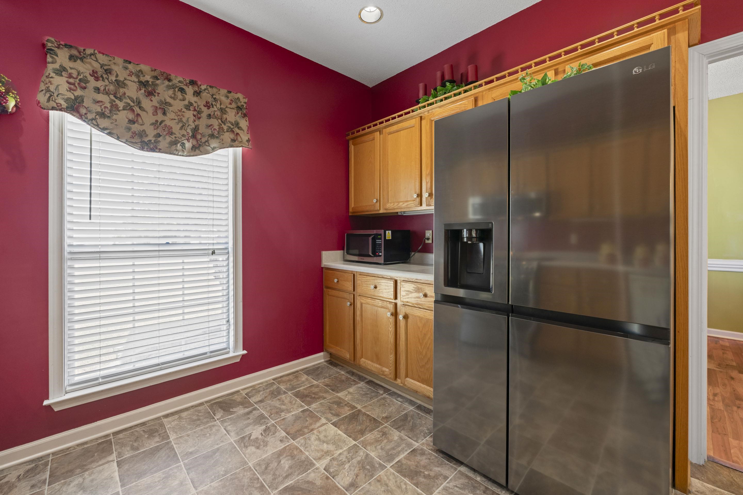 7265 Ward Road Millington, TN 38053 - Photo 9 of 29 Kitchen with stainless steel appliances, light countertops, stone finish floors, brown cabinets, and recessed lighting