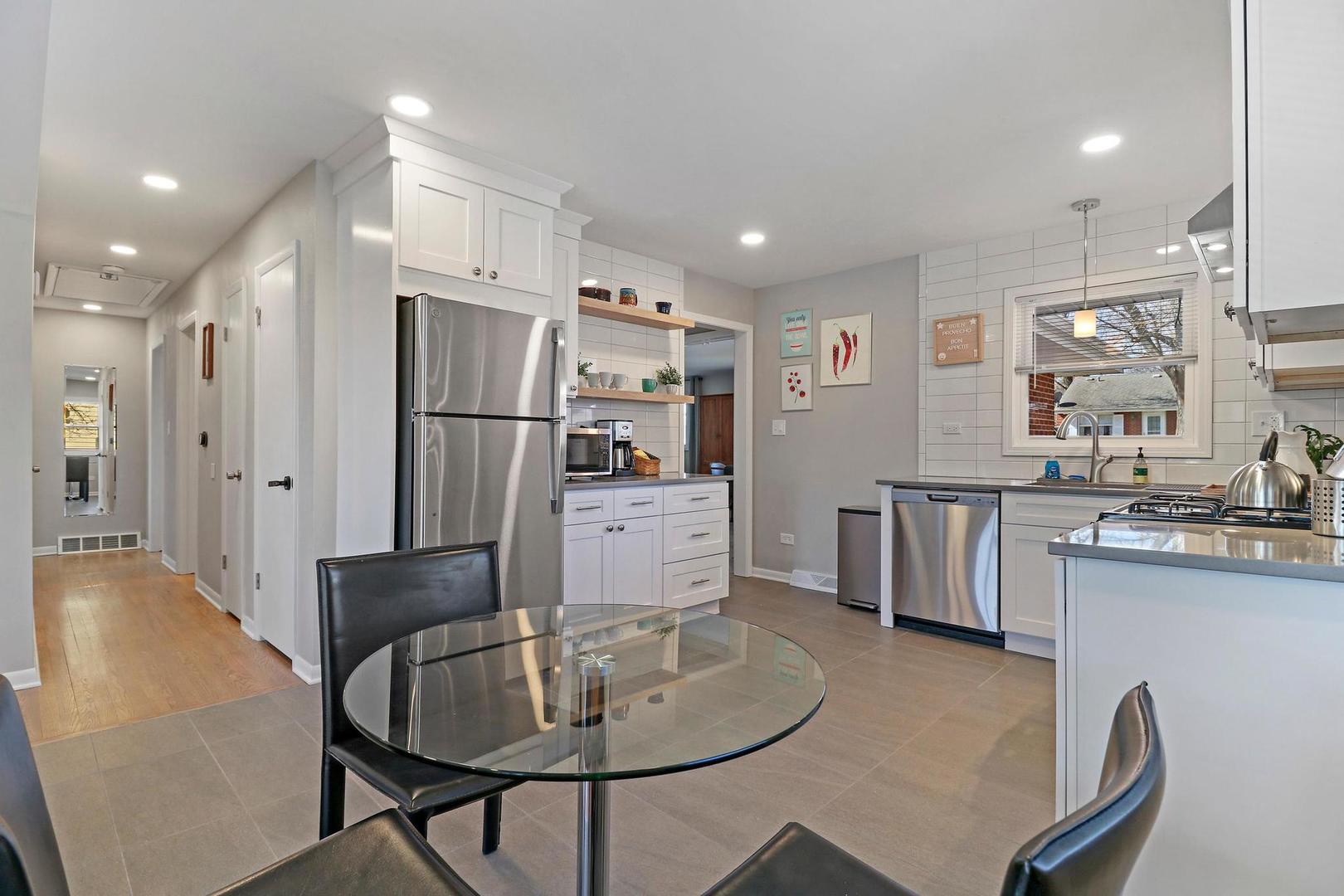 2532 North Jackson Street Waukegan, IL 60087 - Photo 10 of 29 a kitchen with stainless steel appliances granite countertop a refrigerator a sink a stove a dining table and chairs