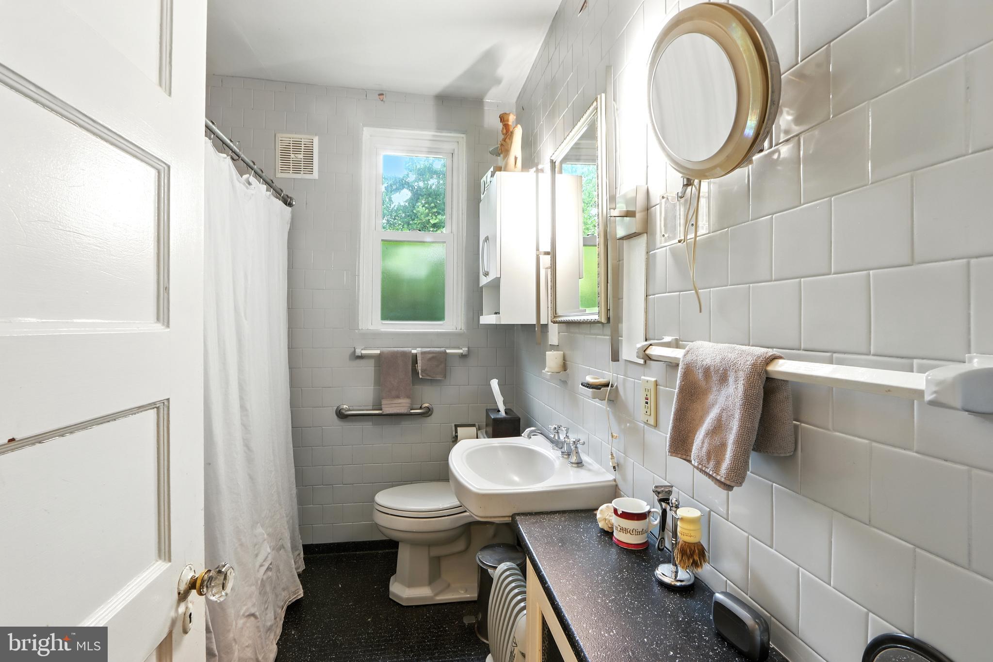 5721 Ridgedale Road Baltimore, MD 21209 - Photo 29 of 54 a bathroom with a sink mirror and toilet