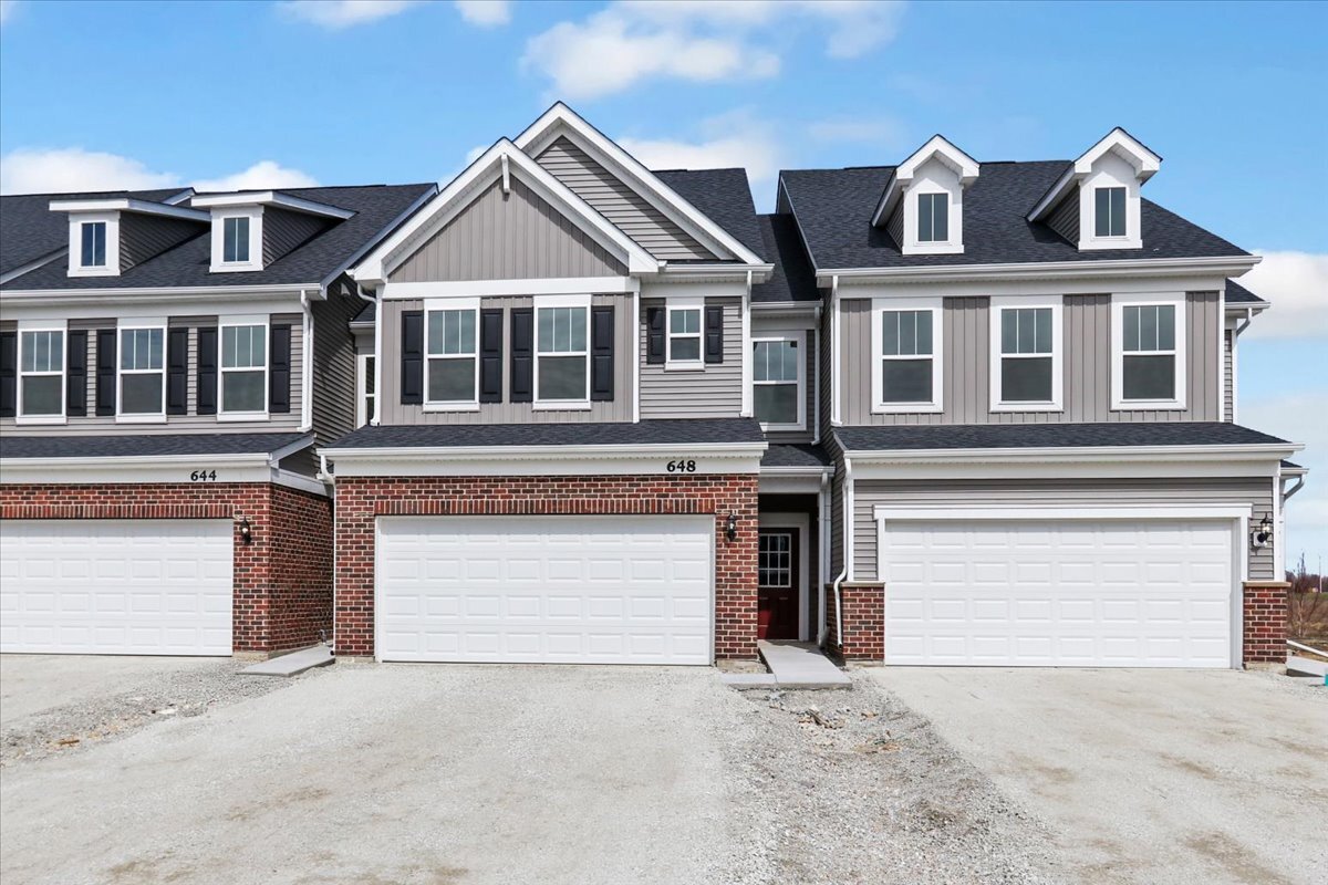 a front view of a house with a garage and a yard