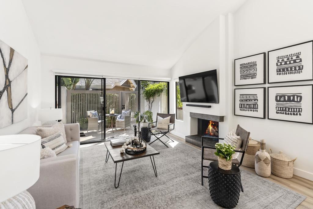 a living room with furniture a flat screen tv and a floor to ceiling window