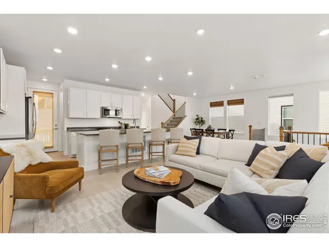 a living room with furniture and a view of kitchen
