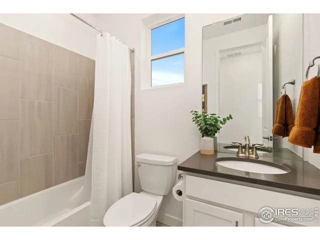 a bathroom with a sink a toilet a mirror and shower