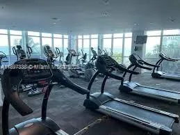 a living room with gym equipment and a table