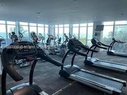 1155 Brickell Bay Drive, Unit 1702 Miami, FL 33131 - Photo 27 of 28 a living room with gym equipment and a table