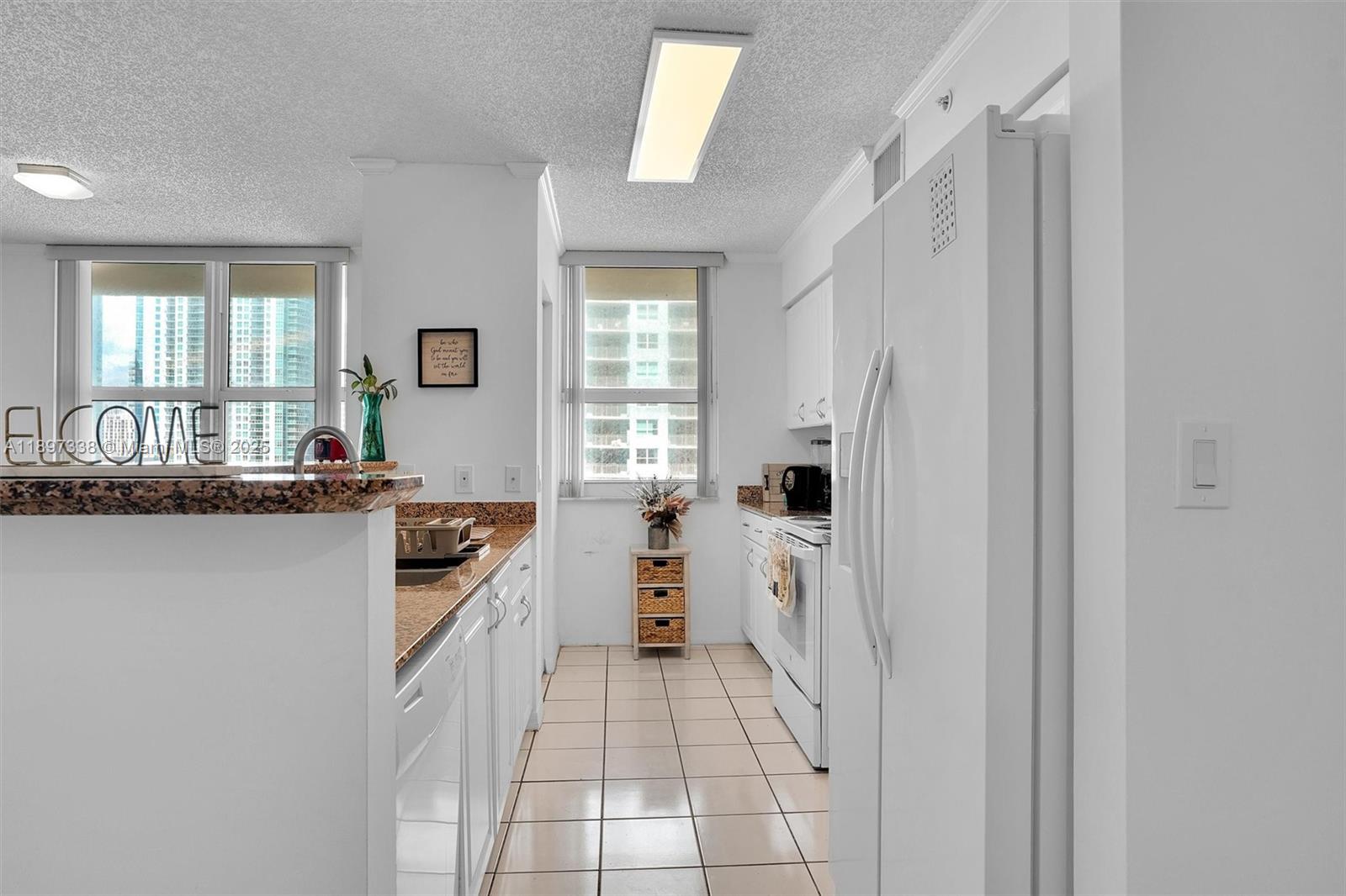 1155 Brickell Bay Drive, Unit 1702 Miami, FL 33131 - Photo 6 of 28 a kitchen with a refrigerator and a stove