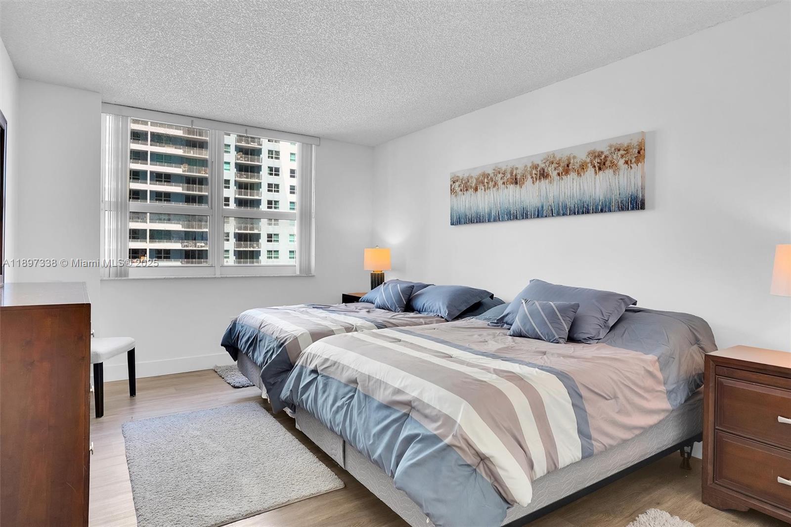 1155 Brickell Bay Drive, Unit 1702 Miami, FL 33131 - Photo 10 of 28 a bedroom with two beds and a large window