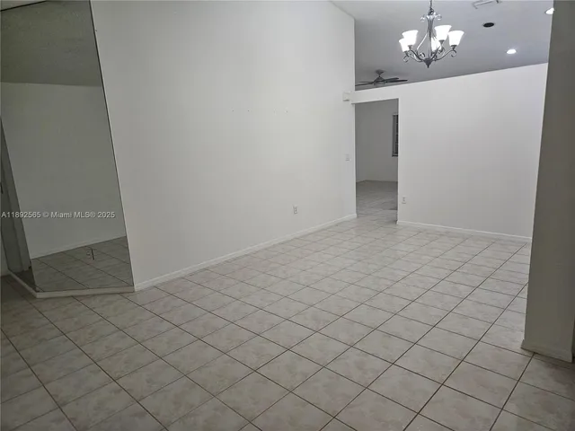an empty room with kitchen view