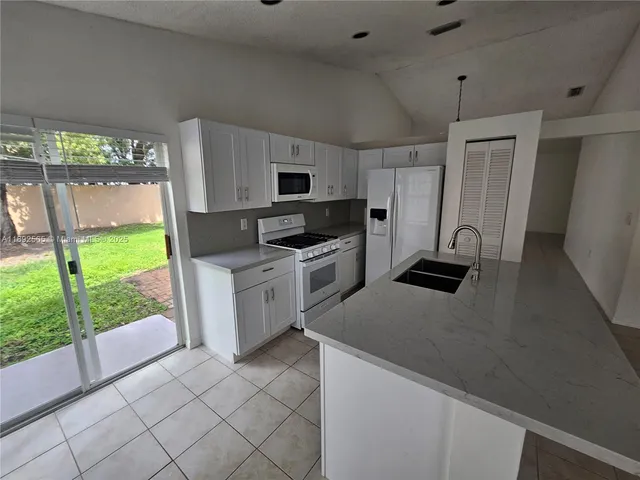 a kitchen with a stove a sink and a microwave