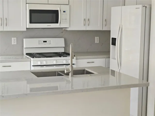 a kitchen with stainless steel appliances granite countertop a refrigerator and a stove